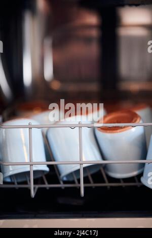 Il processo di lavaggio delle giare di yogrut in lavastoviglie. Produzione di yogurt fatto in casa. Foto verticale. Foto Stock