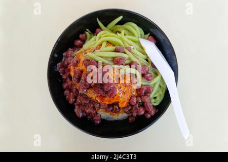 Il Cendol è un dolce fatto con ghiaccio rasato e gelatina di farina di riso verde, latte di cocco e sciroppo. Foto Stock