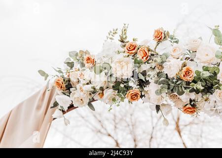 Matrimonio arco rotondo con fiori e tessuto in primavera o in inverno. Il luogo della sposa e lo sposo per la cerimonia in natura Foto Stock