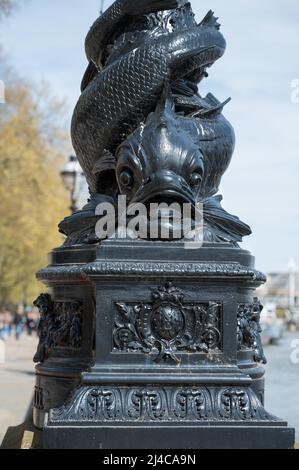 Base decorativa in ghisa di una lampada Dolphin standard sul Tamigi Embankment. Londra, Inghilterra, Regno Unito. Foto Stock