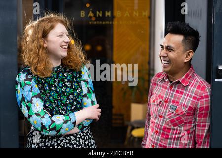 SOLO PER USO EDITORIALE il proprietario del ristorante, Dung Nguyen (a destra) da Banh Banh Cafe con il rappresentante BRIXTON BID, Jessica Dyer come ha annunciato come una delle dieci imprese indipendenti a Londra di essere stato selezionato per ricevere una quota di una sovvenzione di £50.000 come parte del programma Dine Local, Gestito dalla International Downtown Association Foundation e da Brixton BID, e supportato da American Express, Londra. Data di emissione: Giovedì 14th aprile 2022. Foto Stock