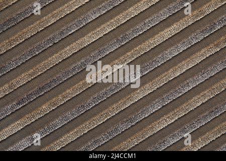 La texture di un tessuto in corduroy di cotone beige naturale con strisce chiare, posizionato diagonalmente. Le creste della corturoia sulla diagonale Foto Stock