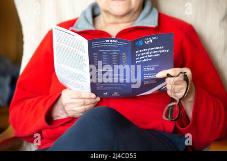 Poznan, Polonia- Marzo 3,2022: Editoriale illustrativo di una donna anziana non identificata che legge il pamphlet 'Polski Lad' (Ordine Polacco). Foto Stock