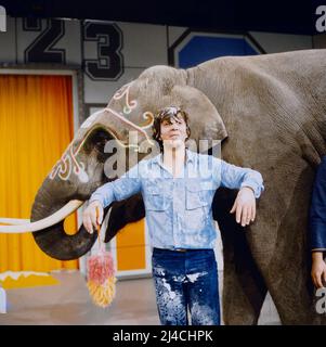 1, 2 oder 3, ZDF Quizshow für Kinder, moderiert von Michel Schanze, auf dem Bild mit einem Elefanten, Deutschland, 1981. 1, 2 oder 3, TV quiz show for Kids, presentato da Michael Schanze, sulla foto con un elefante, Germania, 1981. Foto Stock