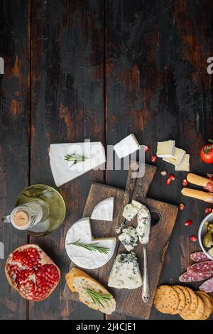 Tavolo di antipasti con diversi antipasti, su sfondo di legno scuro, piatto con spazio per la copia del testo Foto Stock