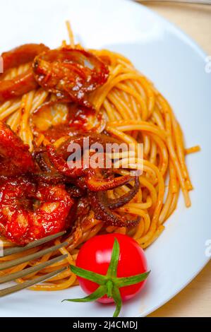 Pesce italiano gli spaghetti in salsa di pomodoro rosso su bianco tavola in legno rustico Foto Stock