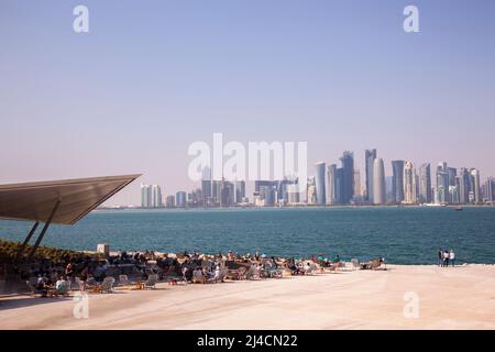 Doha,Qatar - Aprile 22,2022: La gente gode di una giornata di sole nel parco del Museo di Arte Islamica a Doha. Foto Stock