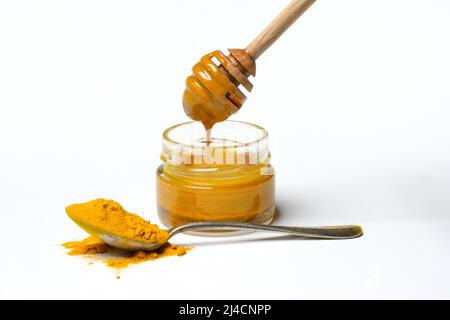 Miele d'ape con curcuma e curcuma in polvere, ingrediente per il latte d'oro, sana bevanda al latte Foto Stock