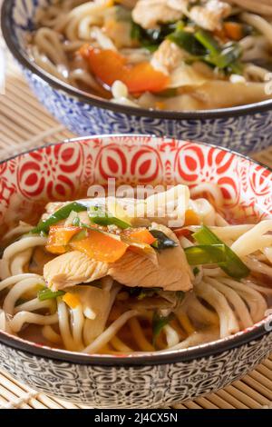 due ciotole di zuppa di noodle in stile thailandese con pollo e verdure, cibo sano Foto Stock