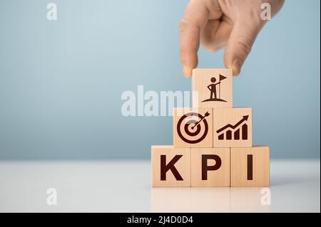 KPI - indicatore delle prestazioni chiave. L'uomo d'affari ha un cubo con l'icona KPI, l'indicatore chiave di prestazioni KPI aumenta il business di ottimizzazione. Pianificazione aziendale Foto Stock