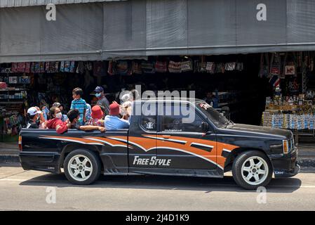 Thailandia, trasporto persone. Veicolo sovraccarico. Carrello raccoglitore completamente carico con persone che si trovano nella parte posteriore . Thailandia Sud-est asiatico Foto Stock