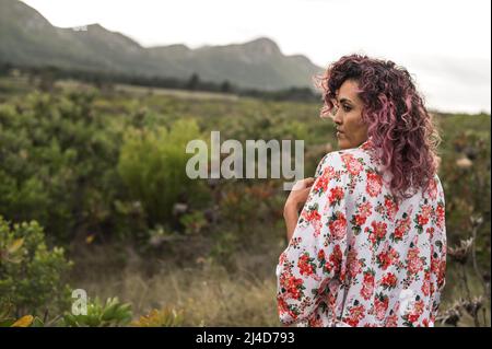 Donna con capelli ricci da dietro in natura Foto Stock