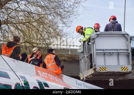 Londra, Regno Unito, 14th aprile 2022. I poliziotti di un selezionatore di ciliegi parlano con i manifestanti. Gli attivisti Just Stop Oil si sono incollati alla sommità di una petroliera e hanno bloccato il traffico sulla rotatoria di Chiswick a Londra occidentale per protestare contro i combustibili fossili. Il gruppo intende interrompere il flusso di petrolio nel capitale. Credit: Vuk Valcic/Alamy Live News Foto Stock