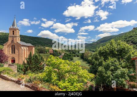 Pieno di alberi verdi e piante in fiore valle Tarn, Chiesa di San Christopher, fiume Tarn del villaggio di Peyre e Viadotto Millau. Aveyron, Francia Foto Stock