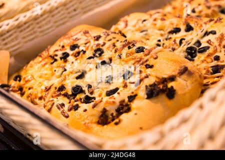 tortilla di grano con formaggio e olive nere sul banco da forno Foto Stock