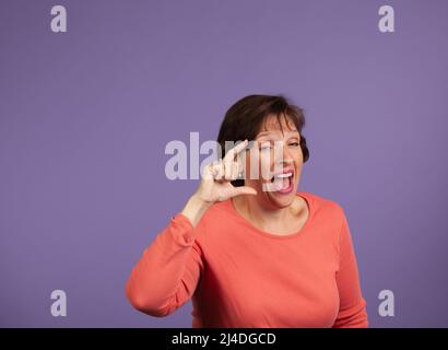 Donna che ride e compiendo gesti di scherno. Divertente donna eccitante concetto. Foto Stock