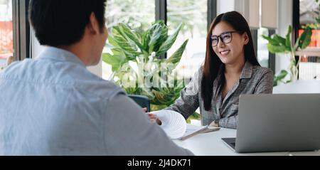 Datore di lavoro o recruiter che legge un riassunto durante circa il colloquio il suo profilo del candidato, datore di lavoro che conduce un colloquio di lavoro, risorsa del responsabile Foto Stock