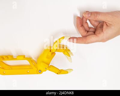 Mano della donna e protesi di plastica per un bambino su sfondo bianco. Foto Stock