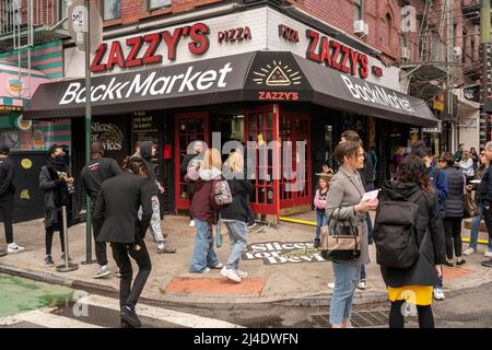 Le persone si affollano a ZazzyÕs Pizza nel quartiere di Lower East Side di New York per partecipare a BackmarketÕs ÒSlices per la promozione DevicesÓ Sabato, 9 aprile 2022.. Backmarket, un rivenditore di tecnologie usate, sta acquistando smartphone idonei usati che danno denaro sul posto. I possessori di telefoni non idonei possono scambiarli con fette di pizza e altri prodotti. (© Richard B. Levine) Foto Stock