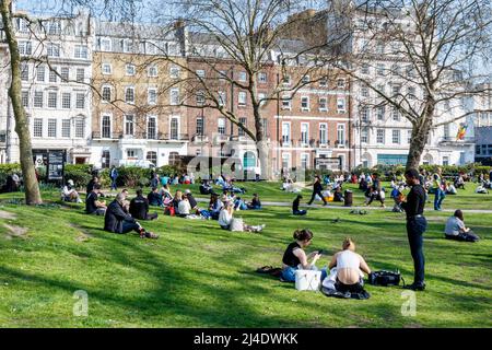 I lavoratori di negozi e uffici fanno una pausa all'aperto per il pranzo mentre il tempo più caldo arriva nel Regno Unito, Cavendish Square, Londra, Regno Unito Foto Stock