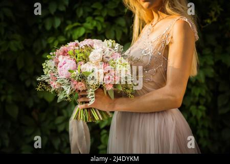 Ritratto di una donna elegante e irriconoscibile che indossa abito da sposa grigio e posa Foto Stock