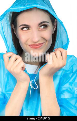 Bella donna con trucco primo piano studio ritratto. Modello indossando il impermeabile blu di plastica e nascondendosi sotto il cofano e tenerlo con le mani. Modello con Foto Stock