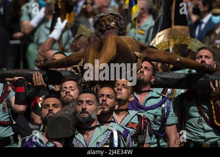 I legionari spagnoli sono visti con una statua del Cristo de la Buena Muerte (Cristo della buona morte) durante un trasferimento il Giovedì Santo in Piazza Santo Domingo, per celebrare le celebrazioni della settimana Santa. Dopo due anni senza la settimana Santa a causa della pandemia del coronavirus, migliaia di fedeli attendono di vedere le processioni che portano le statue di Cristo e della Vergine Maria per le strade come parte della settimana Santa tradizionale. In Andalusia, la celebrazione della settimana Santa accoglie migliaia di persone provenienti da tutti i paesi, ed è considerata uno dei più importanti eventi religiosi e culturali dell'anno. Foto Stock