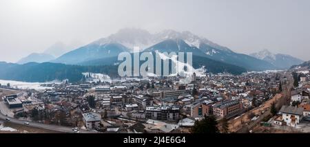 Vista panoramica della bellissima città e montagne innevate contro il cielo Foto Stock