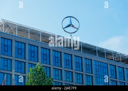 Logo Mercedes-Benz a tre punte sulla parte superiore di un edificio Foto Stock