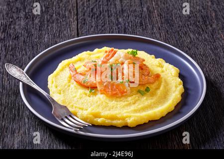 Polenta e schie fritte, piatto veneziano, polenta con gamberi fritti su un piatto con forchetta su tavola di legno scuro, vista orizzontale dall'alto, primo piano Foto Stock