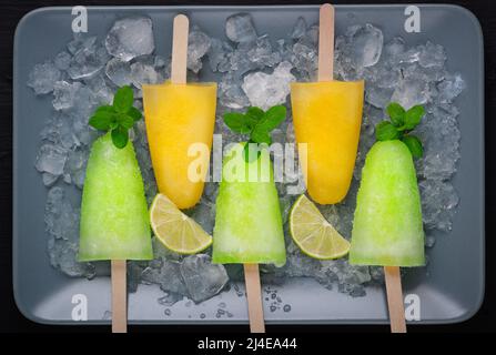 Popsicles fatti in casa con succo di lime, menta e ghiaccio d'arancia lolly Foto Stock