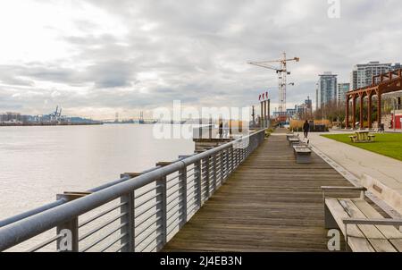 Molo e passerella lungo il fiume in giornata nuvolosa. Bellissimo parco fluviale a New Westminster BC, Canada-Aprile 5,2022. Nessuno, foto di strada, foto di viaggio Foto Stock