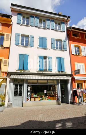 Yverdon-les-Bains, Svizzera - 18 aprile 2017: Casa di locazione quasi bianca situata lungo una strada nel centro storico, le finestre sono dotate di blu w Foto Stock