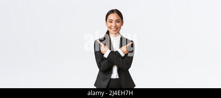 Un venditore asiatico dall'aspetto positivo suggerisce due scelte. Donna d'affari attraente in vestito nero che punta le dita lateralmente, hanno poche varianti, aiutano a fare Foto Stock