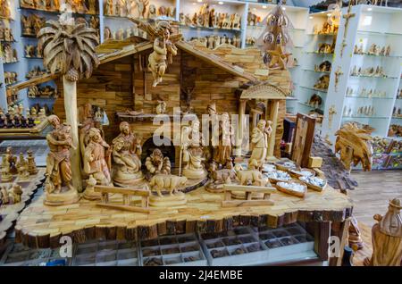 Una bella scultura in legno artigianale raffigurante la nascita di Cristo. Famiglia sacra in legno in vendita in uno degli studi d'arte a Betlemme, Palestina. Foto Stock