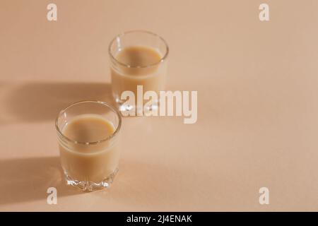 Bicchieri corti di liquore alla crema irlandese o caffè Liquore su sfondo chiaro Foto Stock