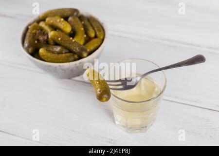 Succo sottaceto, sottaceti e cetrioli marinati in ciotola Foto Stock