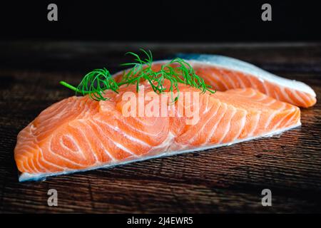 Filetti di salmone crudo guarniti con aneto fresco: Vista a chiosco di filetti di pesce grasso non cotti Foto Stock