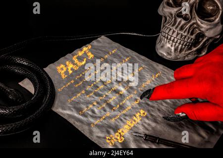 Patto o trattare con il diavolo, affare faustiano e vendere la propria anima al concetto di Satana con mano rossa con artigli che puntano a un contratto scritto nel fuoco Foto Stock