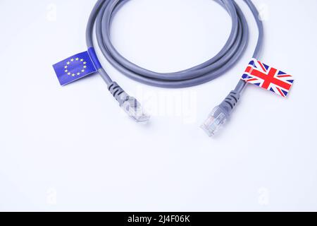 Cavo Internet con bandiera UK ed EU. Cavo Internet con bandiera britannica. Collegamento di un PC a Internet nell'Unione europea. Primo piano del cavo multipolare su un Foto Stock