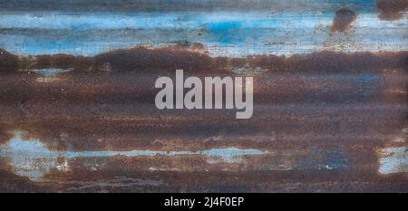 Pannello corrugato in metallo blu con molta ruggine. Foto Stock