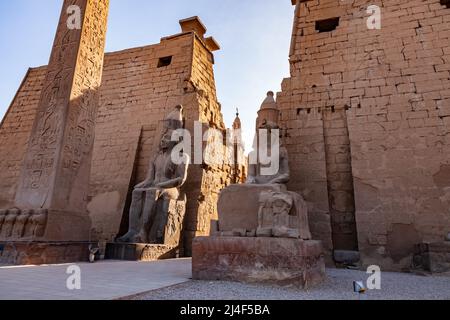 Statue del faraone Ramses II e obelisco al primo pilone del complesso del tempio di Luxor a Luxor, Egitto. Foto Stock