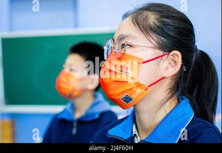 HOHHOT, CINA - 15 APRILE 2022 - gli studenti indossano maschere con il logo della Giornata nazionale dell'educazione alla sicurezza durante una campagna nazionale di educazione alla sicurezza a No Foto Stock