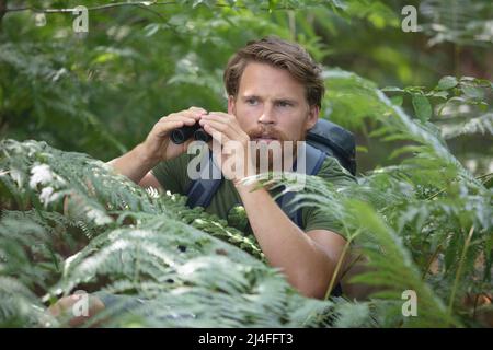 bel viaggiatore spaventato e scioccato con binocolo Foto Stock