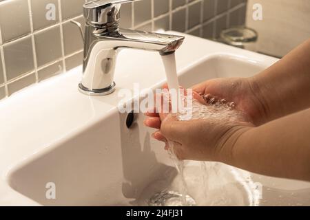 Igiene delle mani dell'uomo per la pandemia di coronavirus precauzione lavando le mani frequentemente per 20 secondi. Foto Stock