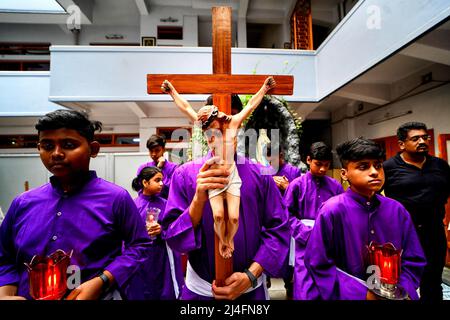 Giovani e devoti cristiani hanno visto portare una croce all'interno dei Missionari della Carità mentre prendono parte alla processione religiosa durante il Venerdì Santo . Il Venerdì Santo è una festa cristiana che commemora la crocifissione di Gesù Cristo e la sua morte al Calvario. Si osserva durante la settimana Santa come parte del Triduo Pasquale il venerdì che precede la domenica di Pasqua, e può coincidere con l'osservanza ebraica della Pasqua. Foto Stock