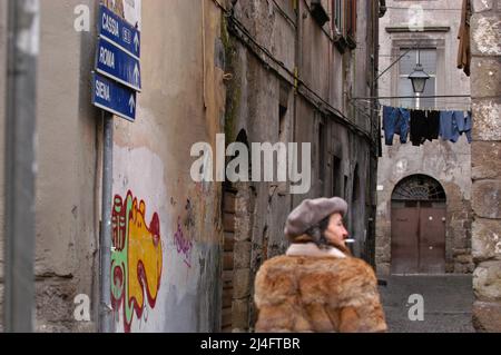 Viterbo, Italy 23/02/2005: Signora in pelliccia fuma una sigaretta, Borgo Medioevale - donna che indossa la pelliccia fuma una sigaretta. ©Andrea Sabbadini Foto Stock