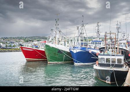 Diverse barche colorate ormeggiate nel porto di Howth. Attrezzatura per la pesca del phishing e della molluschicoltura su imbarcazioni da pesca, Dublino, Irlanda Foto Stock