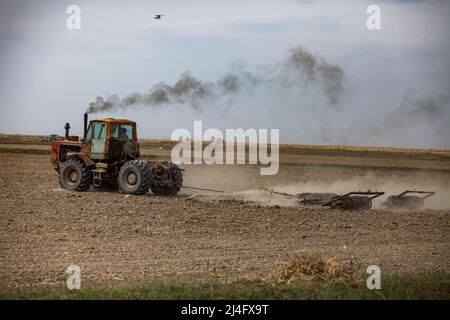 Provincia di Kyzylorda, Kazakistan - 01 maggio 2019: Terreno coltivato a trattore con aratro. Stagione di semina primaverile. Foto Stock