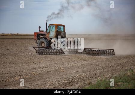 Provincia di Kyzylorda, Kazakistan - 01 maggio 2019: Terreno coltivato a trattore con aratro. Stagione di semina primaverile. Foto Stock